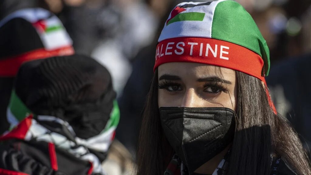 A demonstrator wears a cap in the colours of the Palestinian flag during a pro-Palestinian protest in Berlin on 19 May 2021 (AFP)