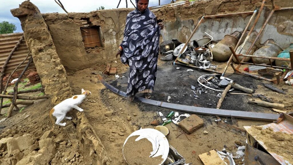 A woman surveys the damage to her house after tribal clashes in al-Roseires, in Sudan's Blue Nile state, earlier this year, 8 August 2022 (AFP)