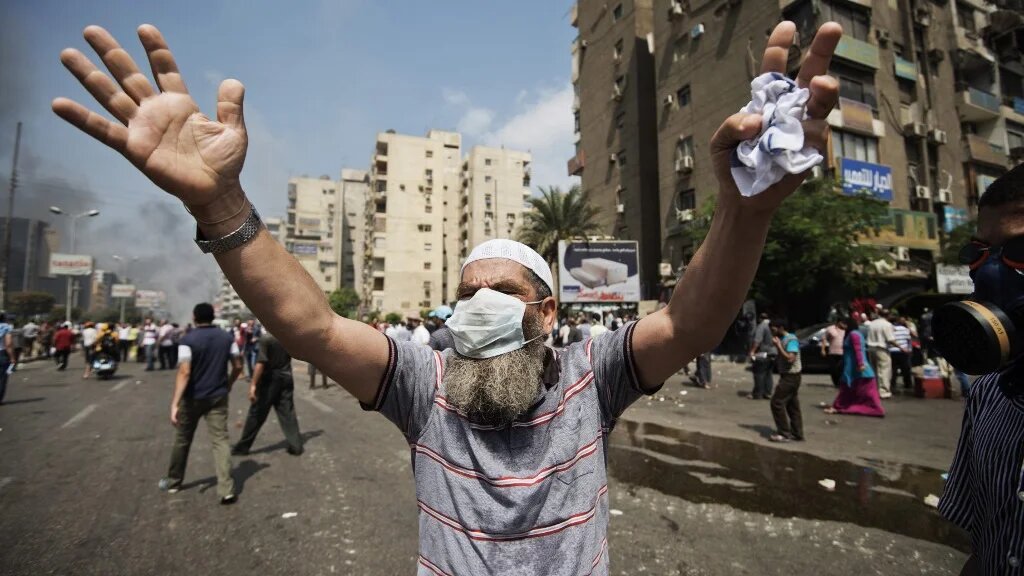 A supporter of Egypt's ousted President Mohamed Morsi gestures during clashes with riot police on a street leading to Rabaa Square in Cairo on 14 August 2013 (AFP)