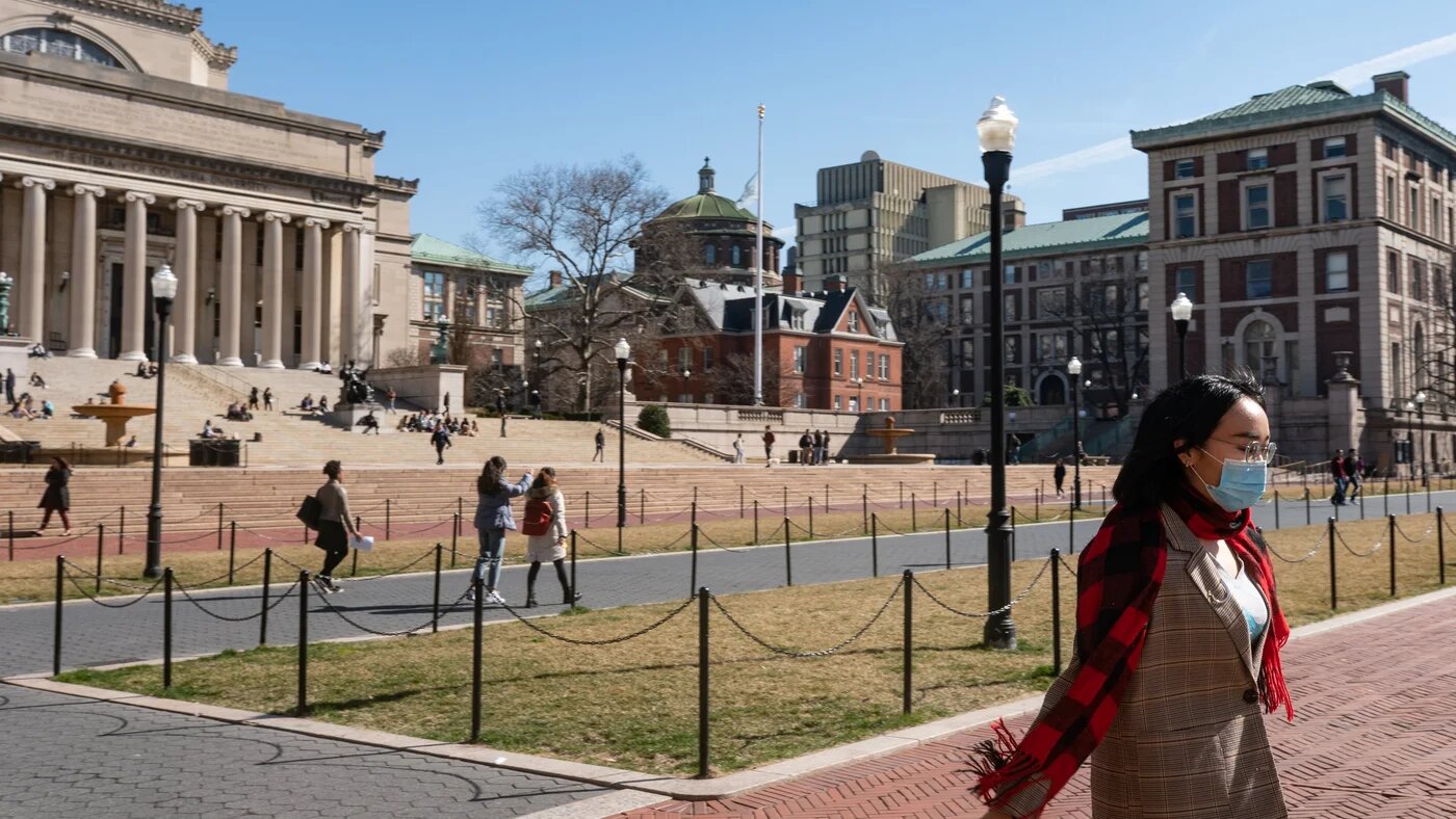 A woman wearing a protective mask walks on the Columbia University campus on 9 March, 2020 in New York City