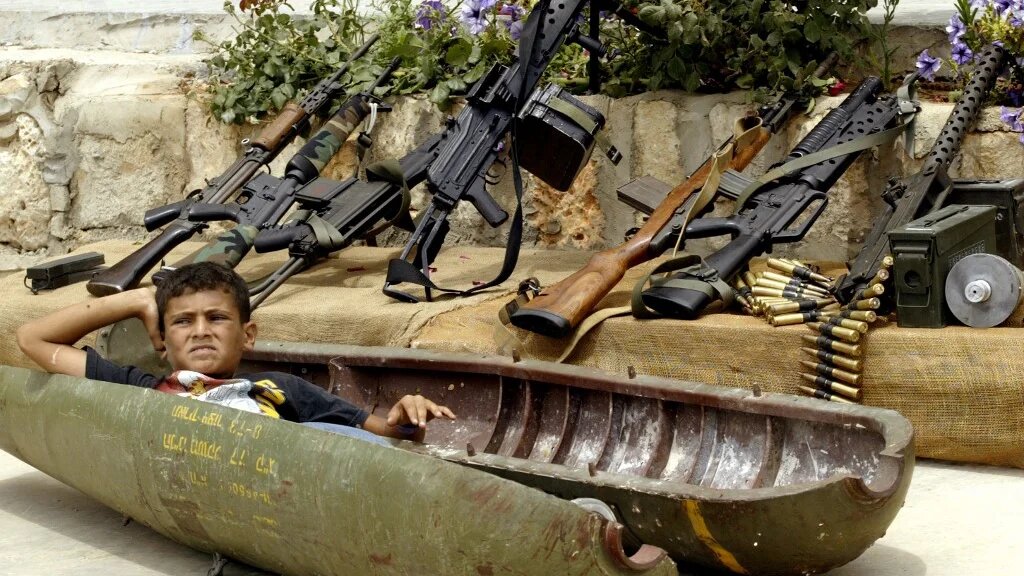 A Lebanese boy relaxes on 15 July 2007 inside a shell dropped by Israeli warplanes during the previous year's war with Hezbollah in the southern village of Aita al-Shaab (AFP/Mahmoud Zayyat)