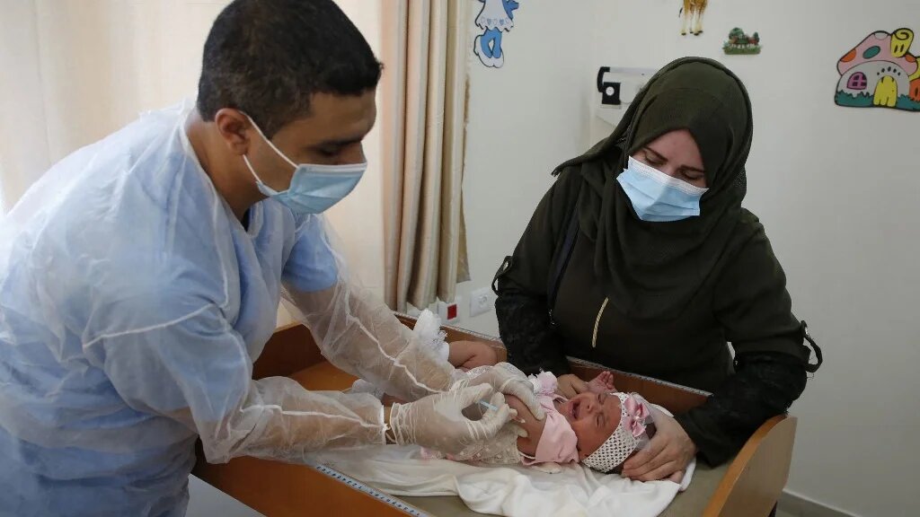 A Unrwa employee provides Polio vaccine for children in a clinic in Bureij refugee camp central of Gaza Strip on 9 September 2020 (Mohammed Abed/AFP)