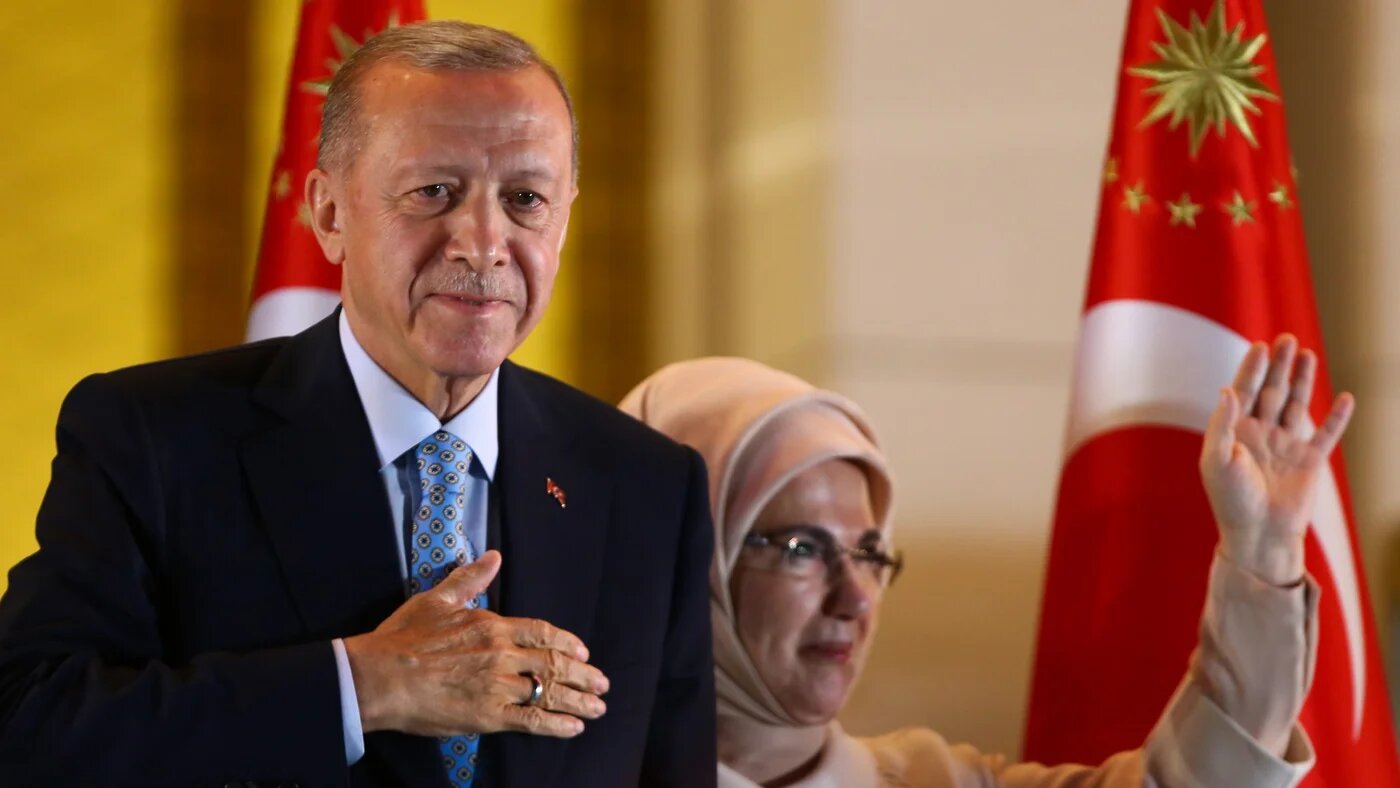 Turkish President Recep Tayyip Erdogan and his wife, Emine, gesture to supporters at the presidential palace, in Ankara, on 28 May 28 (AP)