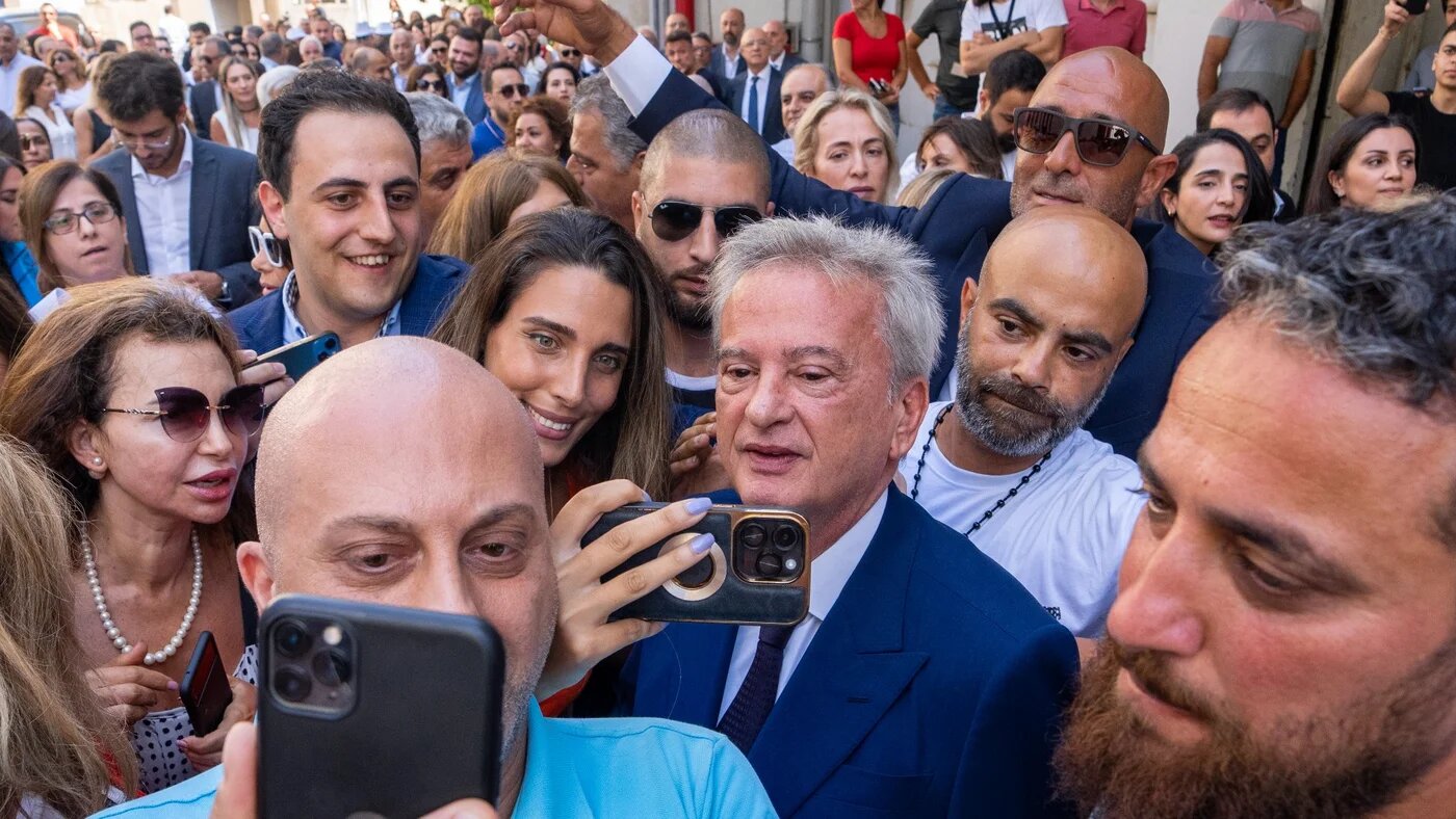 Riad Salameh, centre, Lebanon's outgoing Central Bank governor, greets employees at a farewell party marking the end of his 30 years in office in Beirut, 31 July (AP)