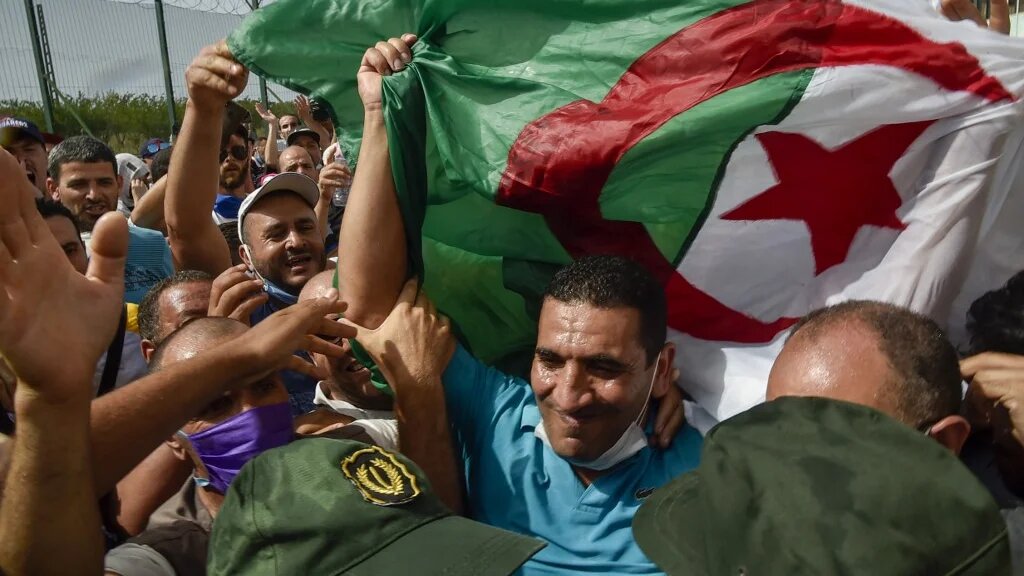 Karim Tabbou, l’une des figures les plus connues du hirak, est salué à sa sortie de prison le 2 juillet 2020, près de la ville de Tipasa, à 70 km à l’ouest de la capitale Alger (AFP/Ryad Kramdi)