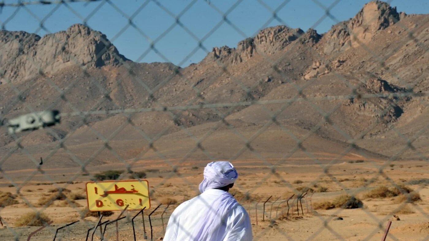 An Algerian man looks at a danger sign at the entrance of the nuclear bomb test site of Tena Fila mountain at Ain Ekra, Algeria, on 25 February 2010 (Fayez Nureldine/AFP)