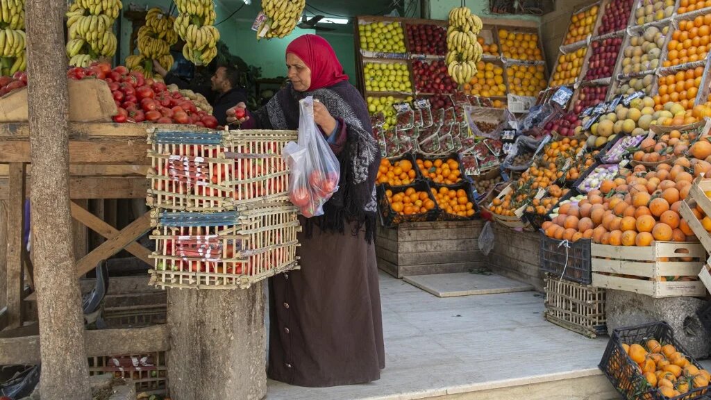 An Egyptian woman shops at a Cairo market, 17 March 2022. By the end of this year, the country's predicted foreign debt will mean that each Egyptian will owe nearly $4k (AFP)