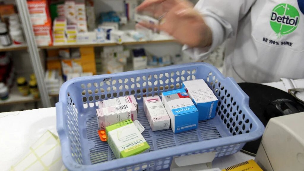 A pharmacist counts items bought by a customer in Tehran (File photo/AFP)