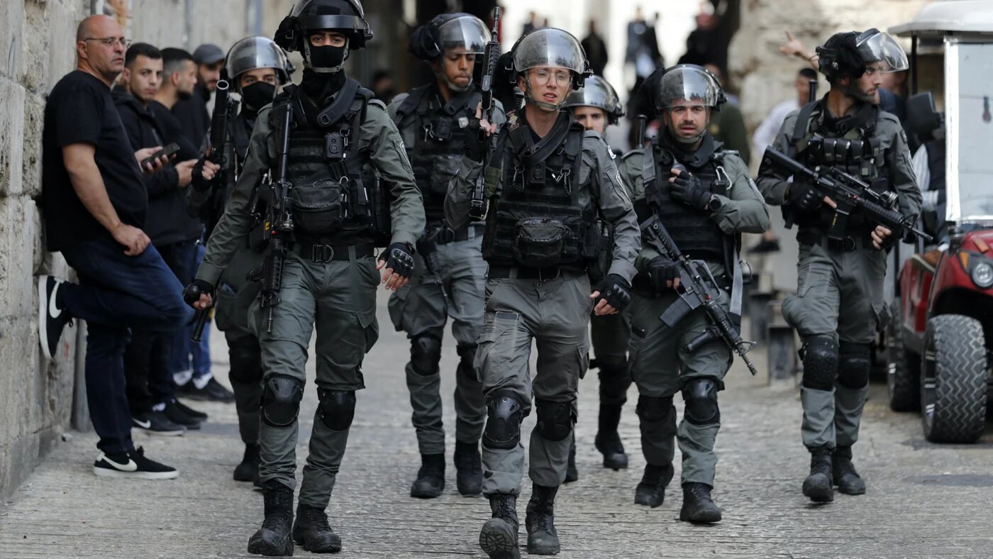Israeli border police patrol in front of the Lion's Gate in Jerusalem's Old City, as Palestinians wait to be allowed to enter the al-Aqsa Mosque compound, on 17 April 2022 (AFP)