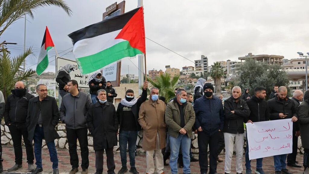 Arab Israelis shout slogans and wave Palestinian national flags in the mostly Arab city of Umm al-Fahm in northern Israel in solidarity with Bedouin communites in the Negev Desert, on January 14, 2022