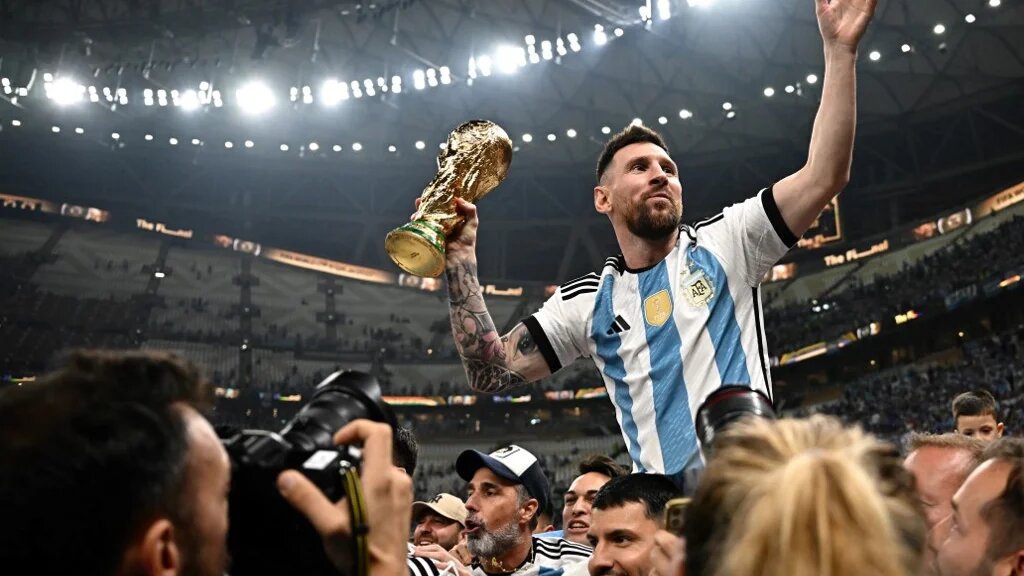 Argentina's captain Lionel Messi (R) holds the Fifa 2022 World Cup after Argentina beat France on penalties in the final at Qatar's Lusail Stadium to be crowned world champions (AFP)