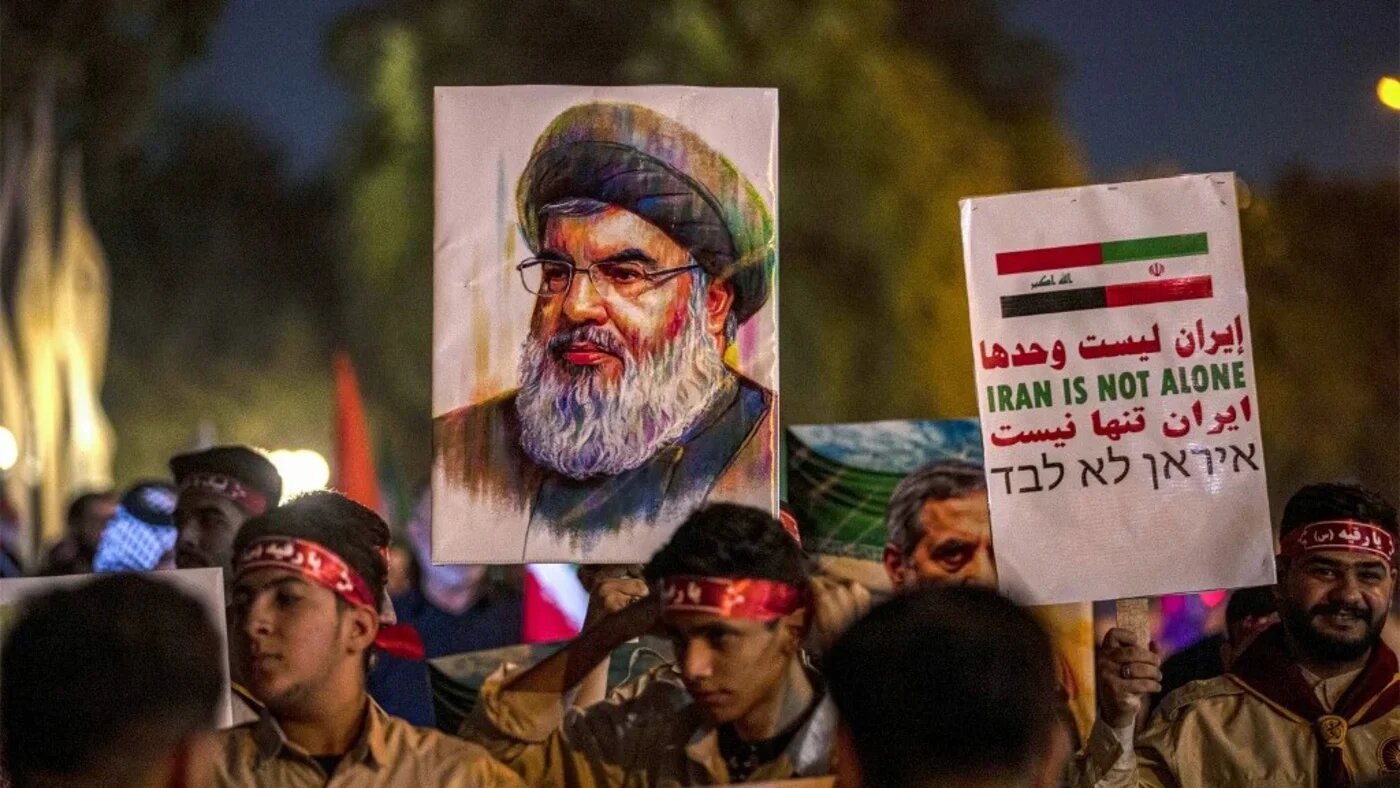 A picture of Lebanese Hezbollah's slain leader Hassan Nasrallah is raised outside the Iranian embassy headquarters in Baghdad on 28 June 2025 (Murtadha Ridha/AFP)