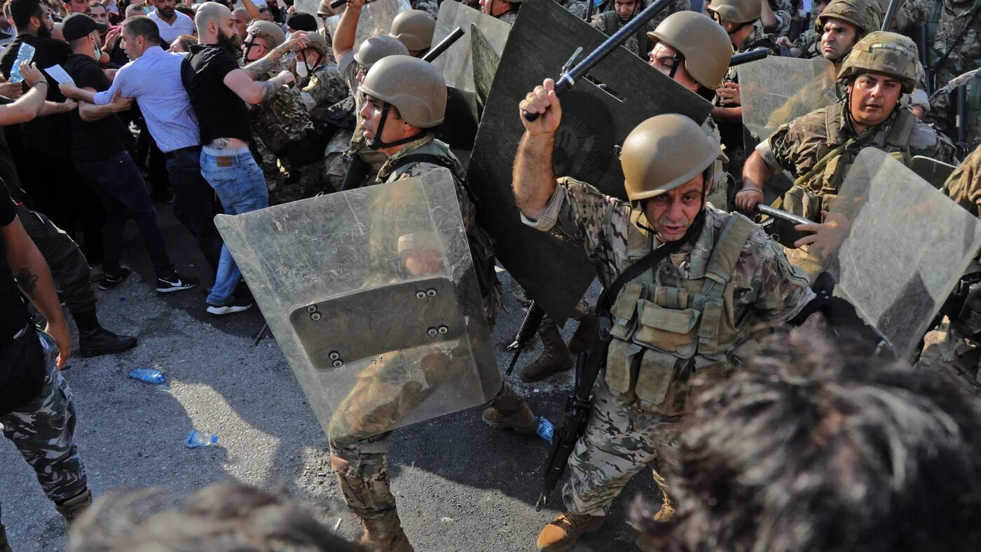 Les forces de sécurité libanaises chargent les manifestants avec des matraques à l’entrée du port de Beyrouth, le 4 août 2021, au premier anniversaire de l’explosion qui a ravagé la capitale libanaise (AFP)