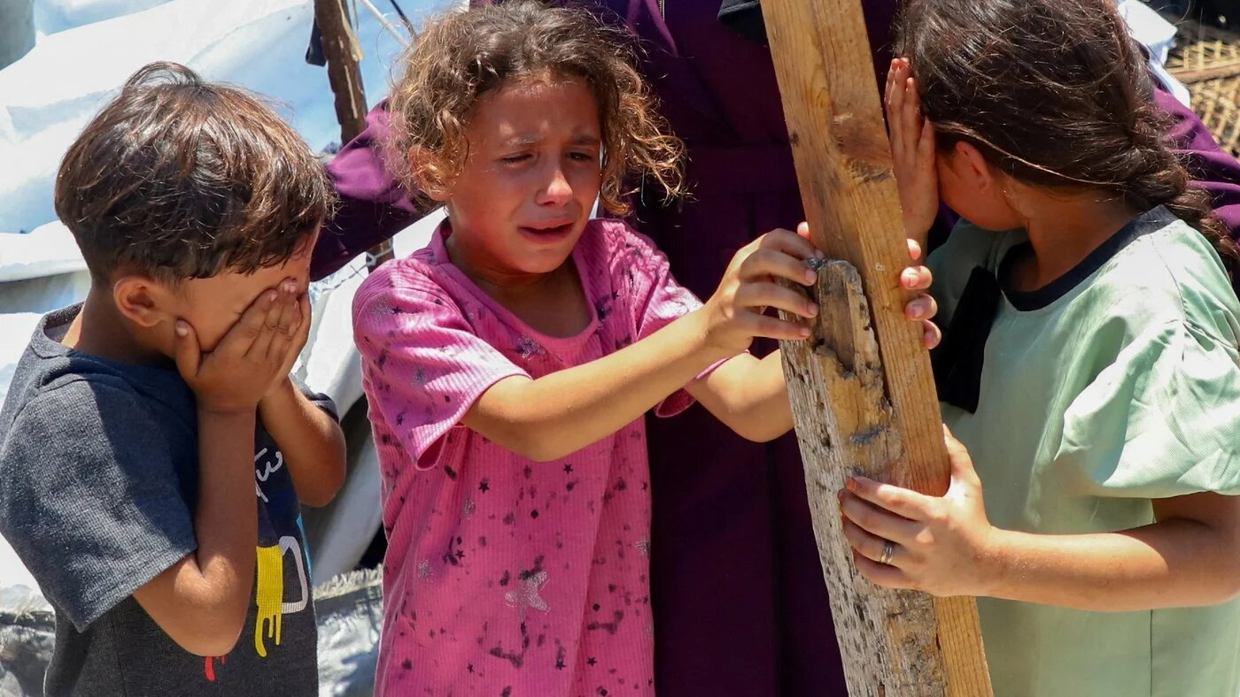 Children react as Palestinians inspect the site of an Israeli strike on a tent at a camp sheltering displaced people, in Gaza City on 7 July, 2026 (Ebrahim Hajjaj/Reuters)