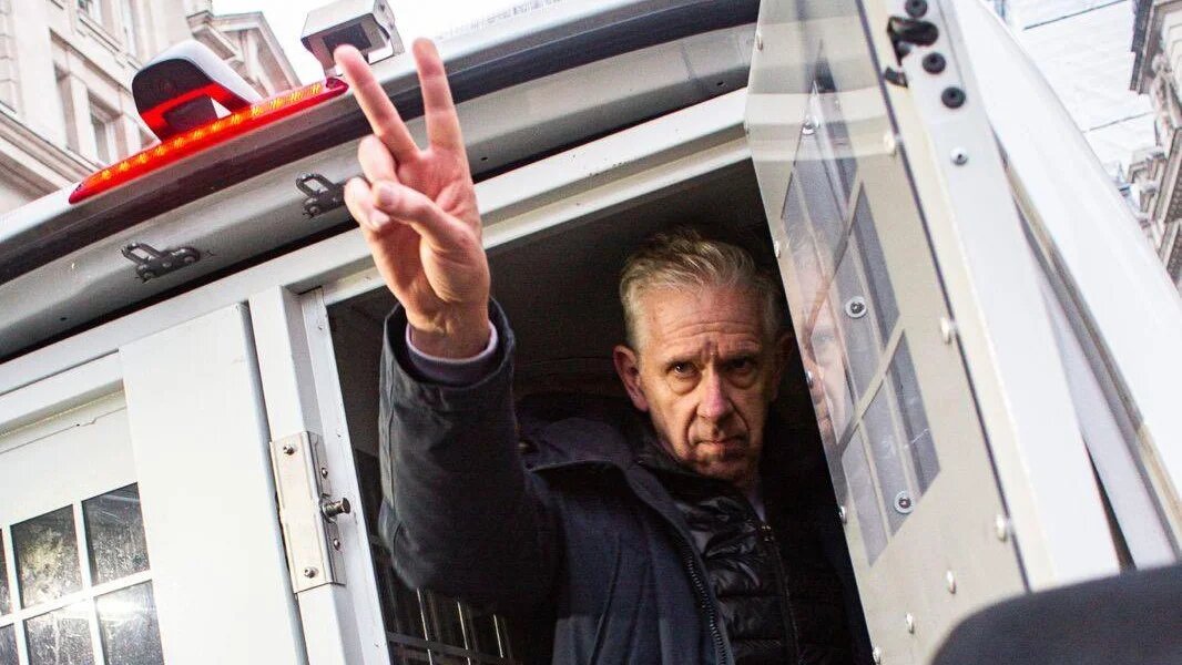 ​Chris Nineham gestures from a police van in central London on 18 January 2025 (PSC)