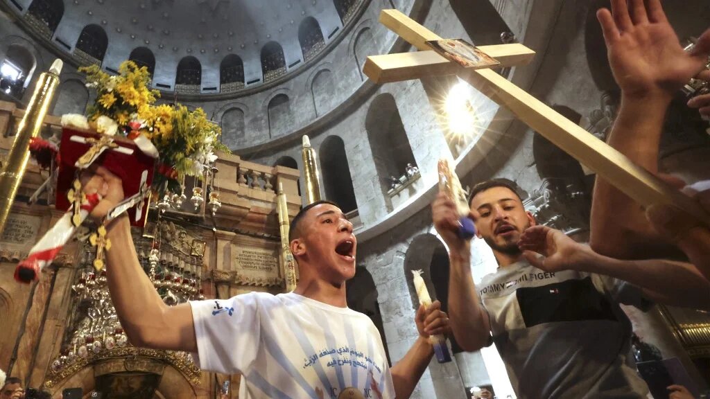 Christians gather around the Edicule, traditionally believed to be the burial site of Jesus Christ, during the Holy Fire ceremony at Jerusalem's Holy Sepulchre church, on 23 April 2022 (AFP)