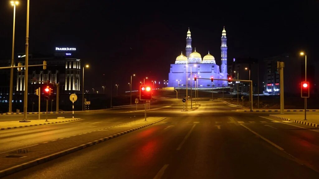 An empty road is pictured with the Bahwan Mosque in the Omani capital, Muscat