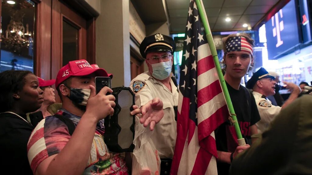 Police officers keep those affiliated with white supremacists separate from demonstrators attending a protest for Daniel Prude
