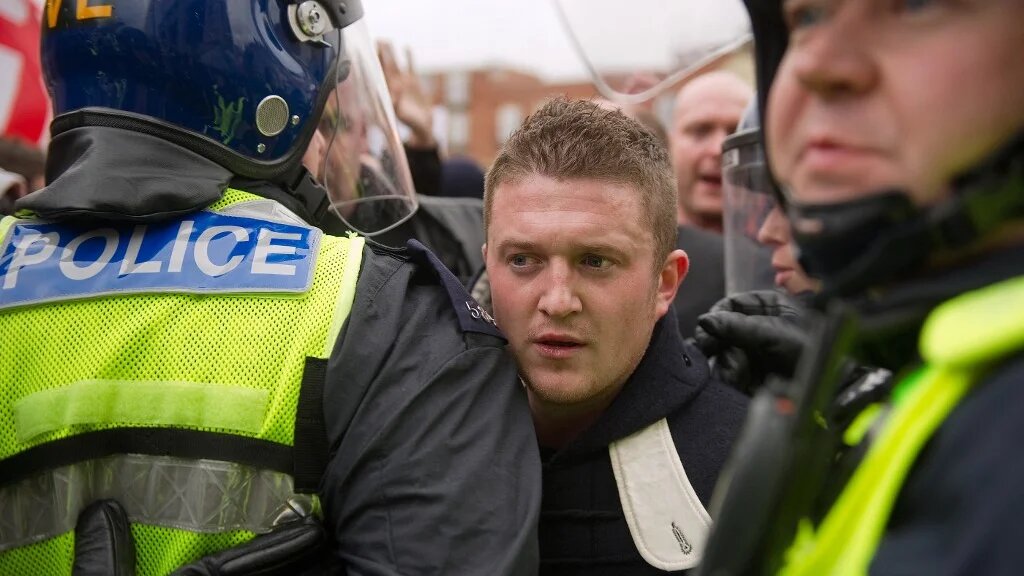 Stephen Lennon (AKA Tommy Robinson) passes between police officers during a far-right rally in Luton, Hertfordshire, on February 5, 2011 (AFP / Leon Neal)