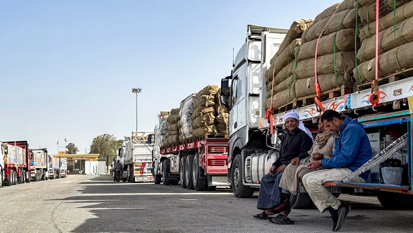 Truck drivers wait next to their vehicles transporting humanitarian aid on the Egyptian side of the Rafah border crossing with Gaza on 27 January 2026. AFP 
