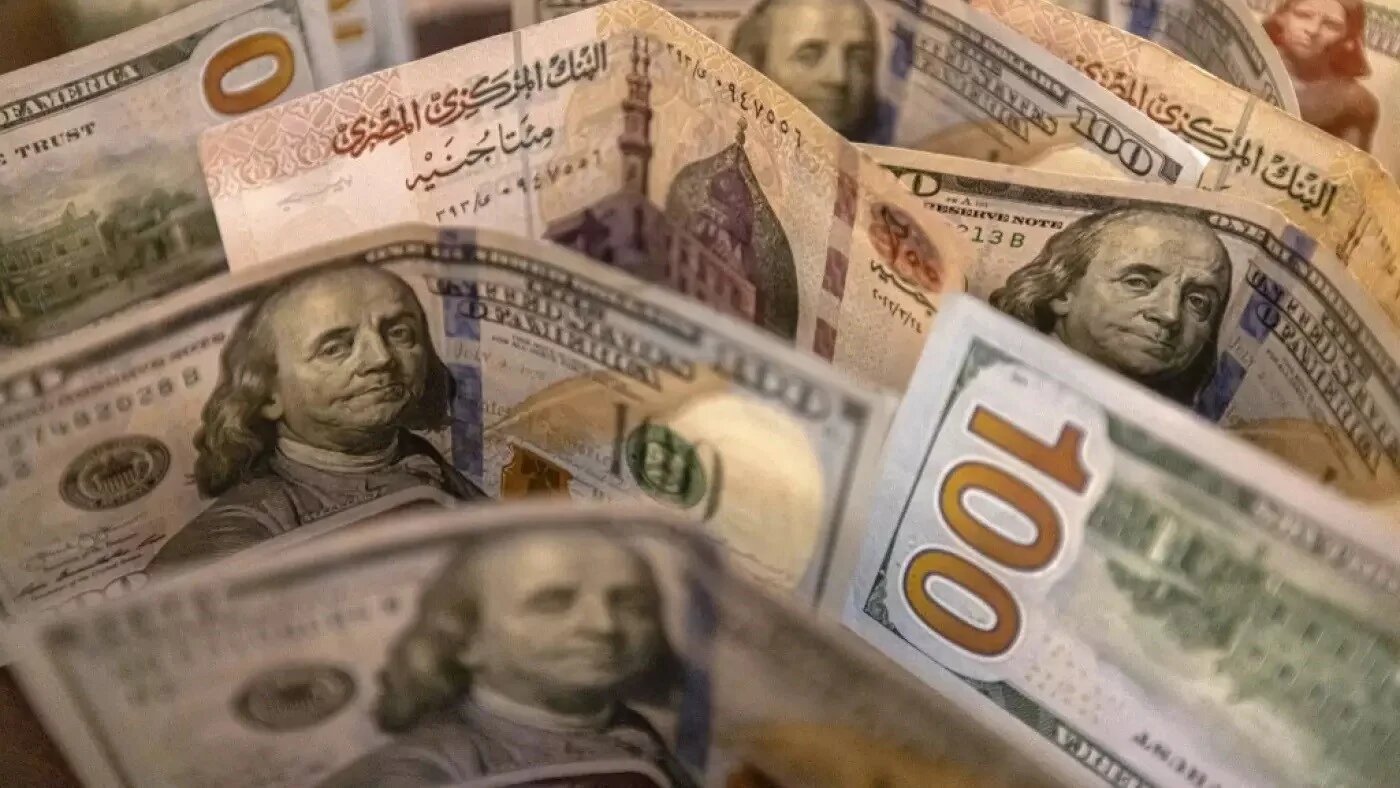A picture taken on August 25, 2022 shows Egyptian pound and US dollar banknotes (AFP/Khaled Desouki)