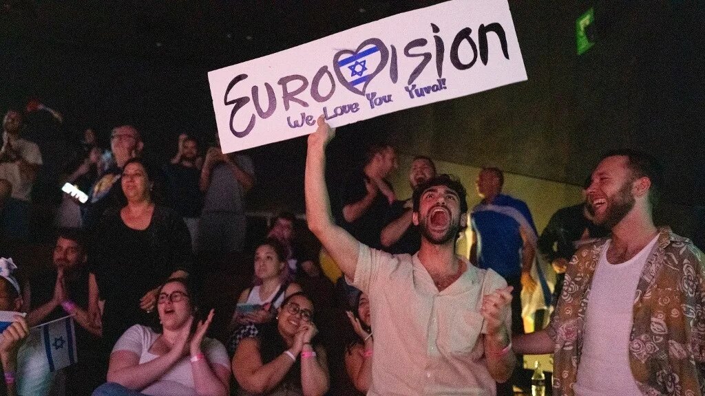 People react as they watch the votes being counted during the 2025 Eurovision Song Contest being screened at a community centre in Tel Aviv, Israel, early on 18 May 2025 (Maya Levin/AFP)