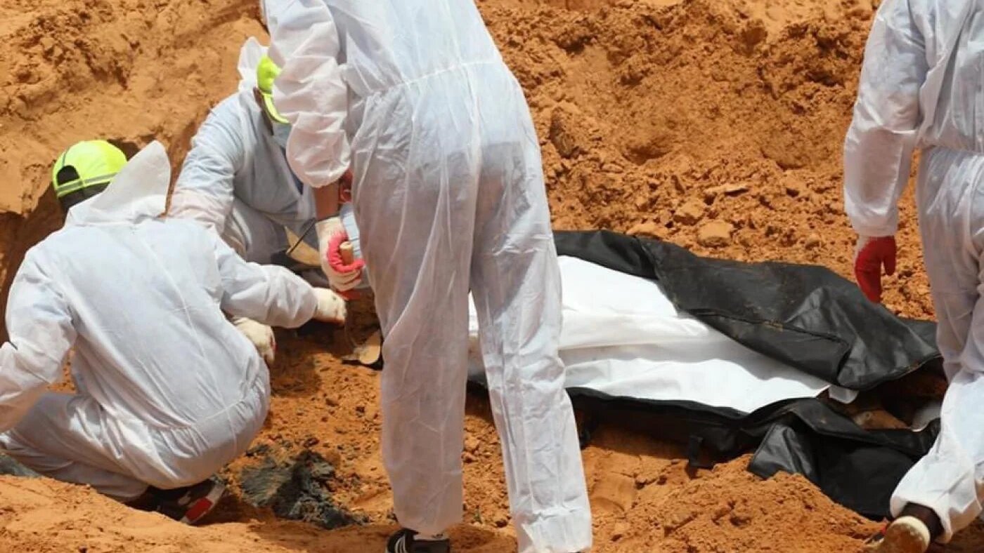 Des membres du Croissant-Rouge libyen et de l’Autorité générale pour la recherche et l’identification des personnes disparues récupèrent des corps dans une fosse commune à Tarhounah (Twitter/@Burkanly)