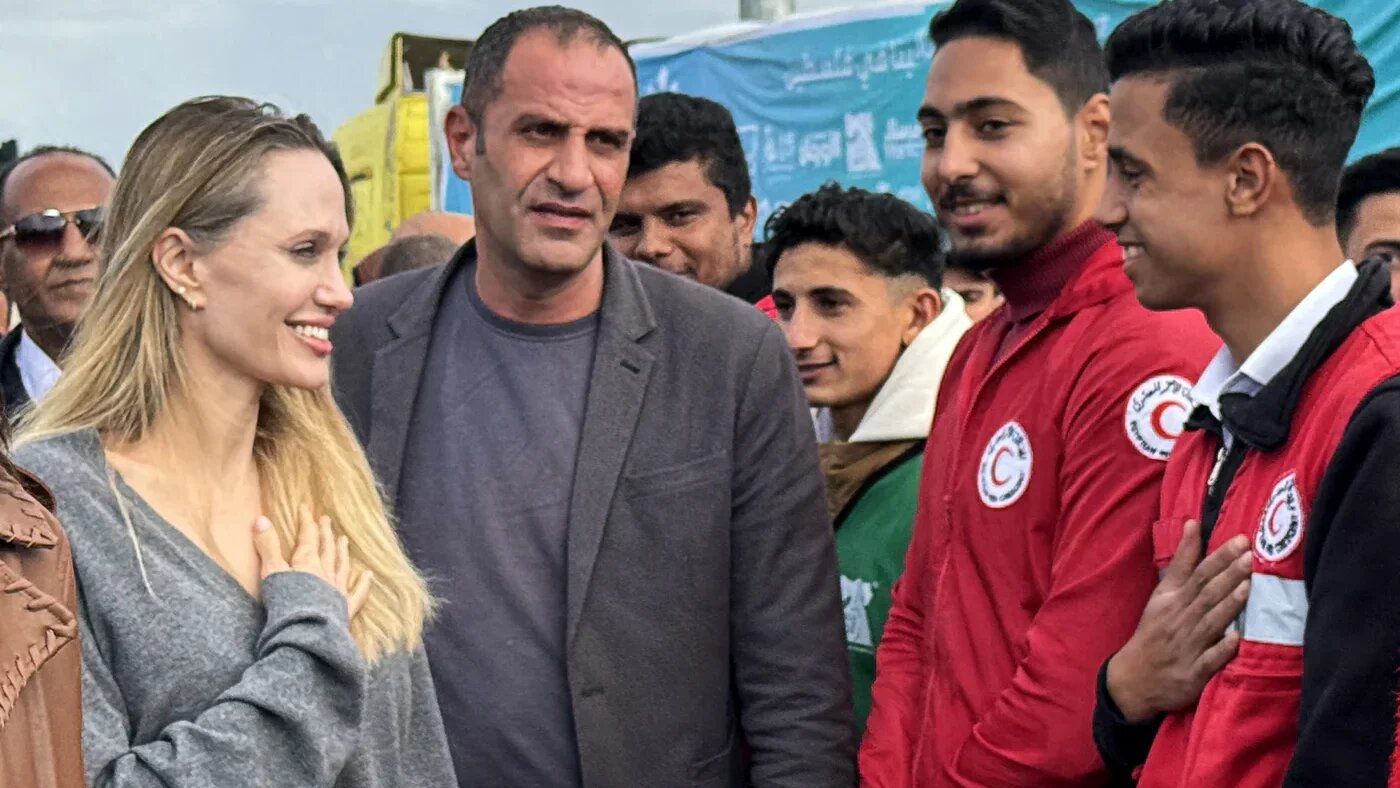 American actor and former UN special envoy Angelina Jolie greets an employee of the Egyptian Red Crescent at the Egyptian Rafah border crossing to Gaza on 2 January 2026 (AFP)