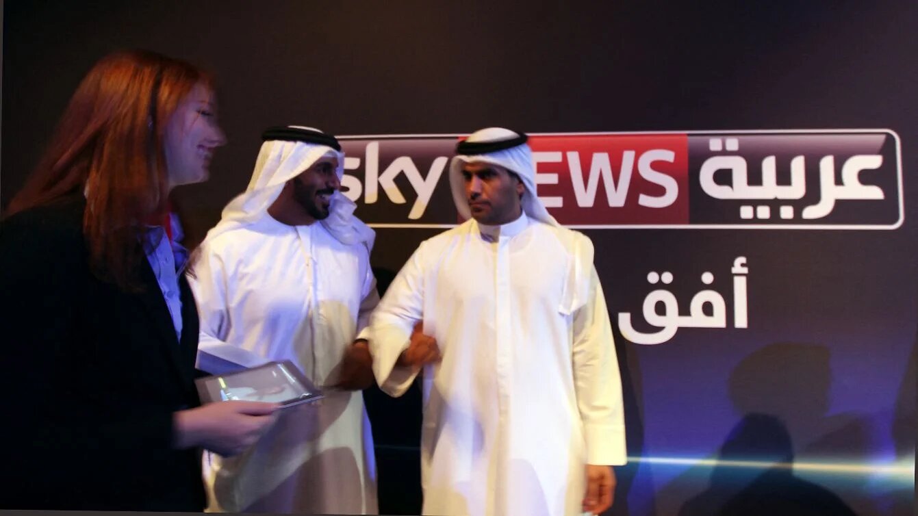 Emiratis stand in front of Sky News Arabia logo during network launch in Abu Dhabi, 6 May 2012 (Marwan Naamani/AFP)
