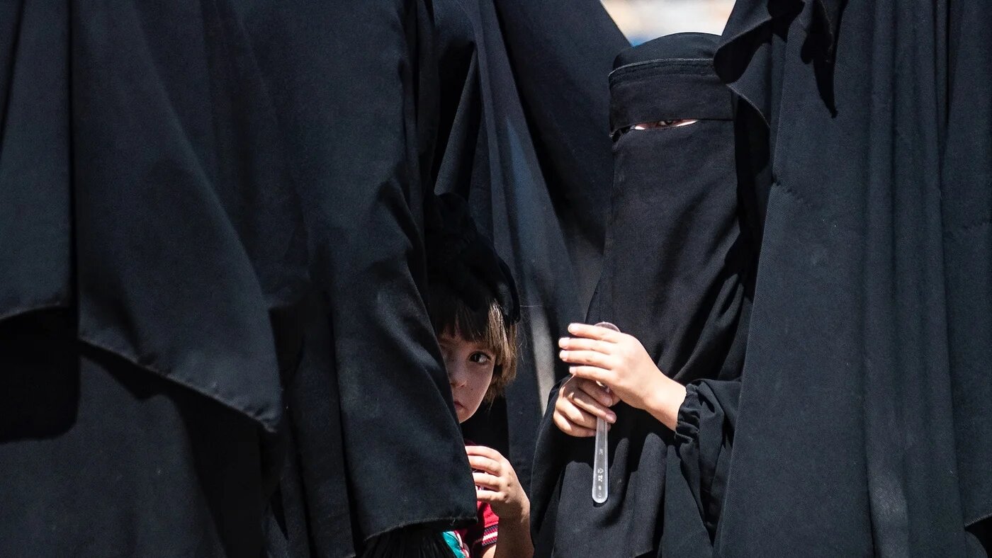 Des enfants attendent avec des membres de leur famille à l’intérieur du camp d’al-Hol, qui accueille des proches de combattants présumés du groupe État islamique (EI) dans le gouvernorat de Hasakeh (nord-est), le 15 juillet 2021 (AFP)