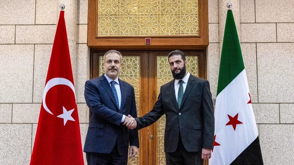 Turkey's Foreign Minister Hakan Fidan (L) and Hay'at Tahrir al-Sham (HTS) leader Ahmed al-Sharaa meet in Damascus on 22 December 2024 (Turkish Foreign Ministry/AFP)