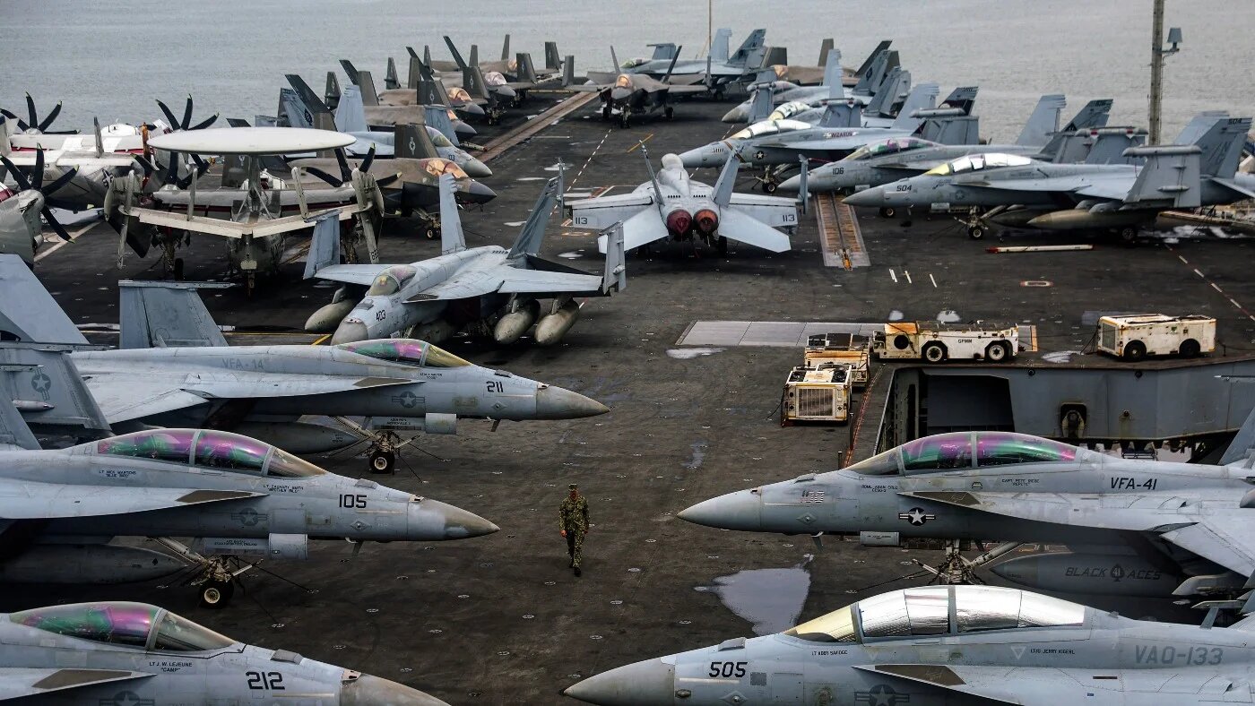 A US Navy officer walks past fighter jets on aircraft carrier USS Abraham Lincoln on 26 November 2024. FAZRY ISMAIL / POOL / AFP (FILES)
