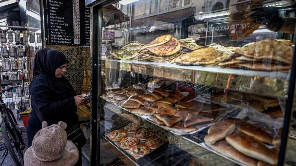 A woman buys bread in bakery at Malta bazaar at Fatih district in Istanbul, Turkey on 6 December 2024 (Ozan Kose/AFP)