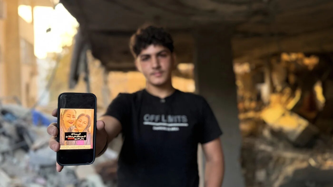 Fourteen-year-old Fuad shows a photo of his mother and grandmother, who were killed in Israeli airstrikes on a residential building in western Gaza City, 3 October 2026 (Hani Abu Rezeq/MEE)