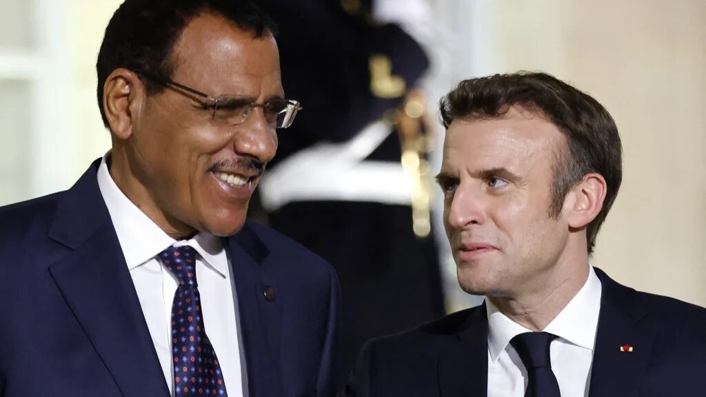 France's President Emmanuel Macron (R) welcomes Niger's President Mohammed Bazoum (since deposed in a coup) ahead of a meeting on the Sahel with leaders from the region, in Paris, 16 February 2022 (AFP)