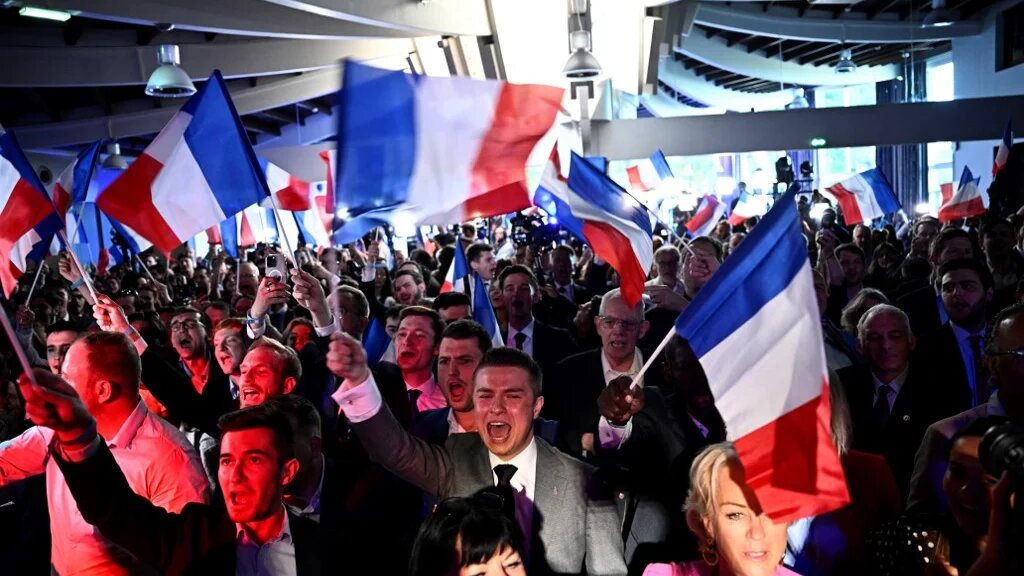 Far-right National Rally party members celebrate the announcement of the European Parliament election results at the Pavillon Chesnaie du Roy in Paris on 9 June (Julien de Rosa/AFP).