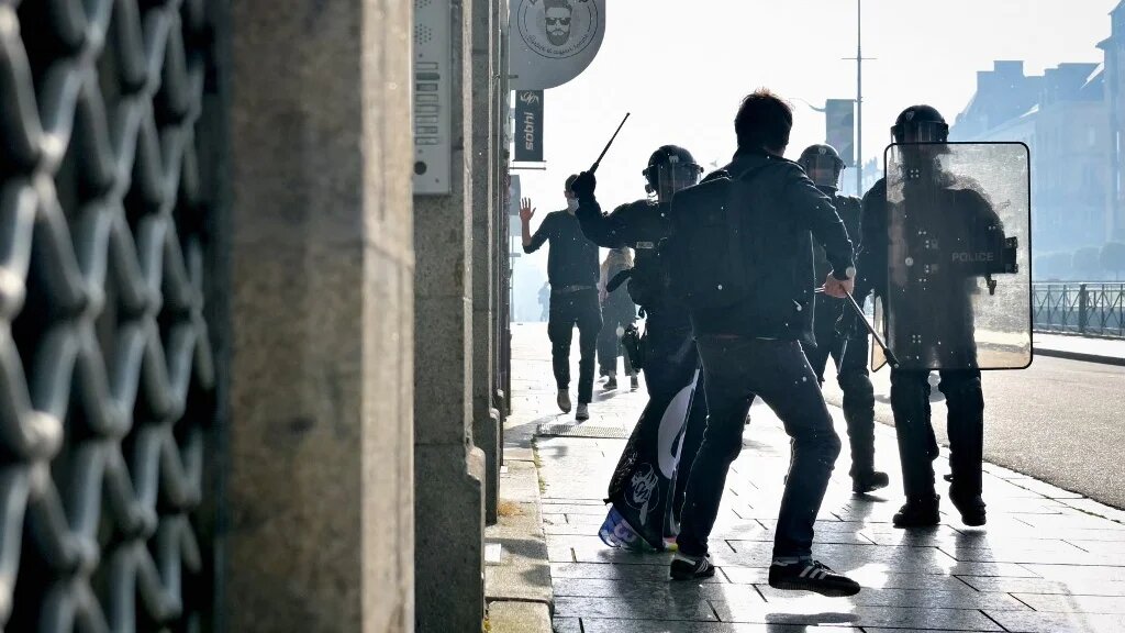 Riot police officers charge at a protester during a demonstration against the rise of far-right parties, in Rennes, northwestern France, on 20 June (Lou Benoist/AFP)