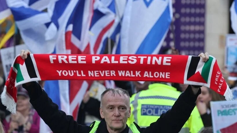 A pro-Palestine marcher stands in front of a counter-protest organised by a pro-Israel group in central London, 30 November 2024 (AFP)