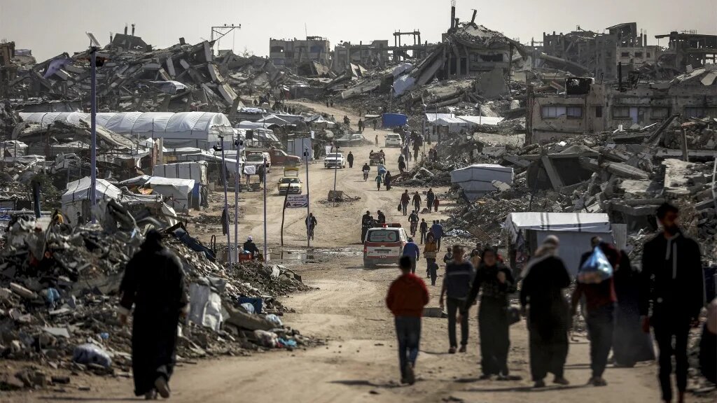 People walk past the rubble of destroyed buildings in the Jabalia camp for Palestinian refugees in the northern Gaza Strip on 8 February, 2026. (AFP/Omar al-Qattaa)