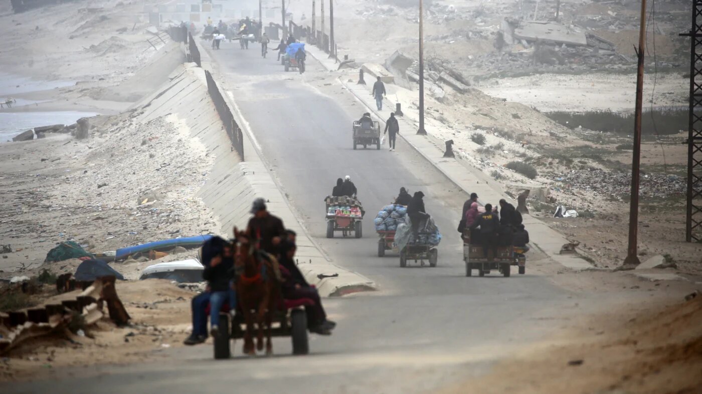 Palestinians ride vehicles with their belongings as they flee from northern Gaza towards the south via the Salahuddin Road on 20 March 2025 (Eyad Baba/AFP)