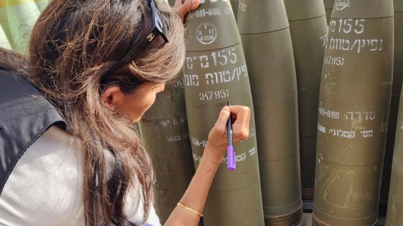 A picture posted on social media shows Nikki Haley writing 'finish them' on an Israeli shell (Danny Danon)