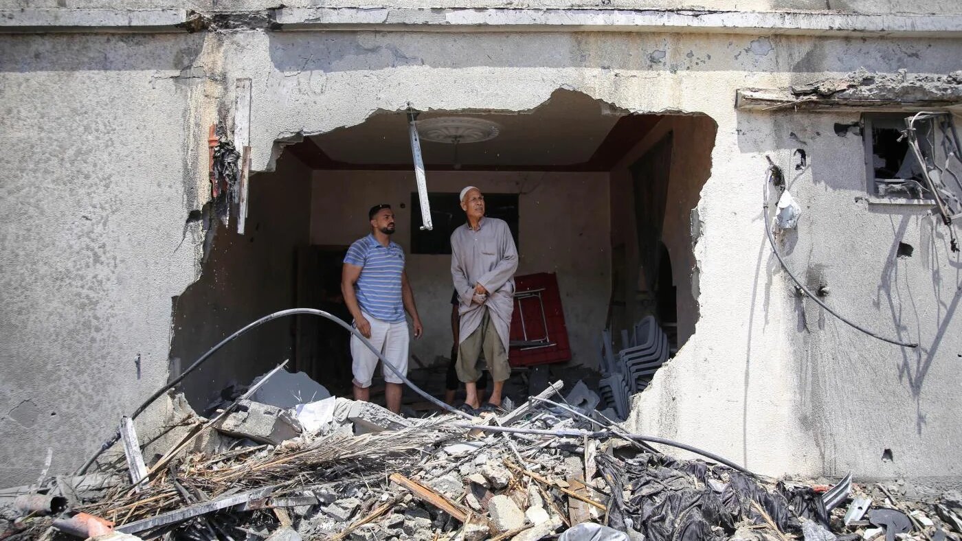 Des Palestiniens inspectent les restes d’une maison détruite par les frappes aériennes israéliennes sur la bande de Gaza, le 6 août 2022 (MEE/Mohammed al-Hajjar)