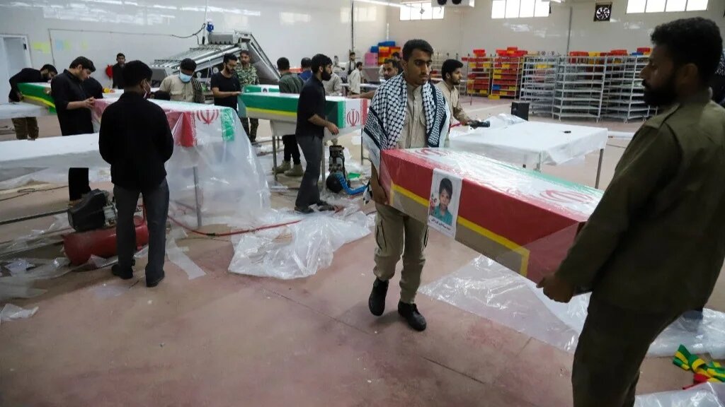 Mourners prepare the coffins of children who were killed in a strike on a primary school in Iran’s Hormozgan province for a funeral in Minab on 3 March 2026 (Amirhossein Khorgooei/ISNA/AFP)