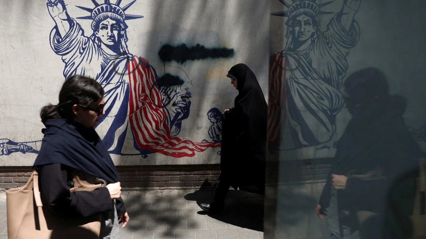 Iranian women walk past an anti-US mural on a street in Tehran, Iran on 1 June 2026 (Majid Asgaripour/WANA via Reuters)