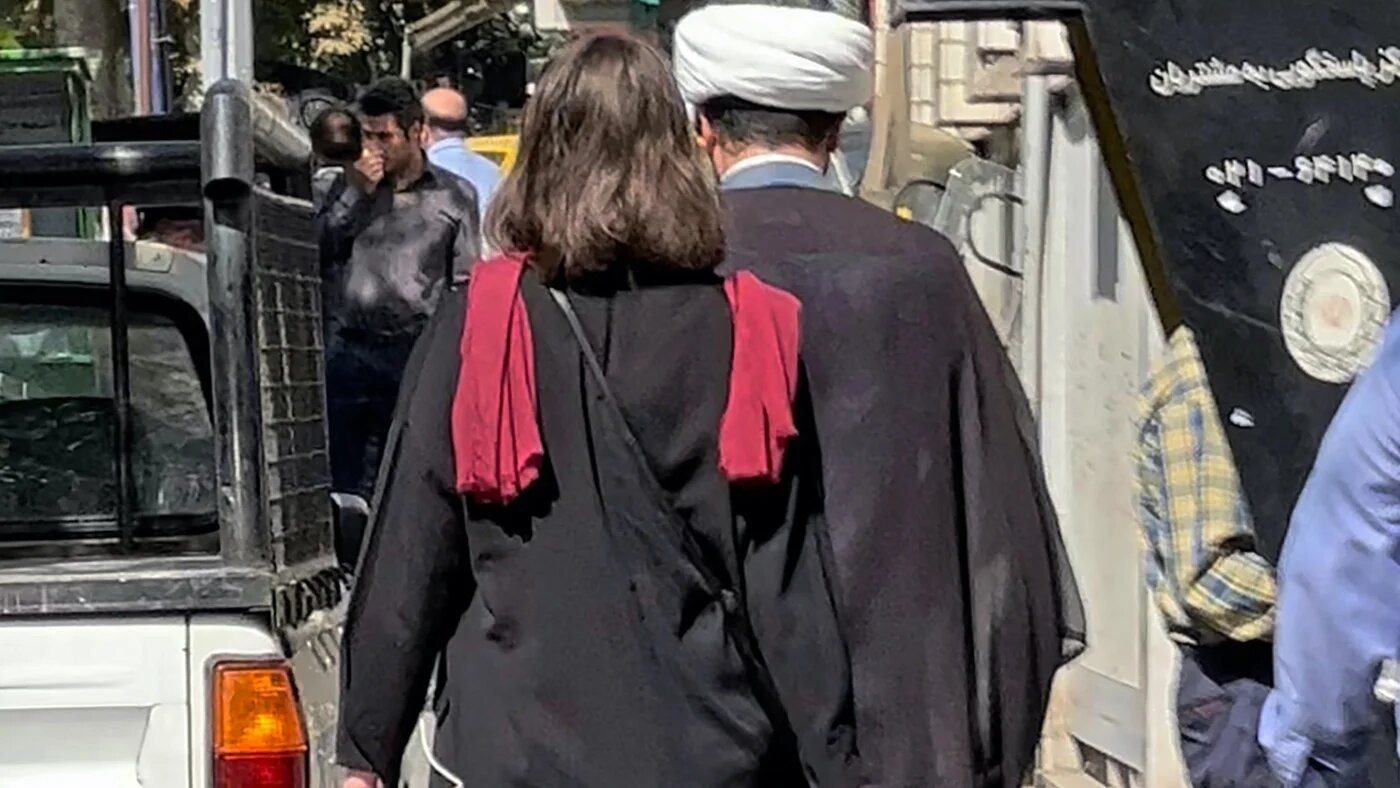 A woman walks without a headscarf in the Iranian capital Tehran, on 11 October 2022 (AFP)