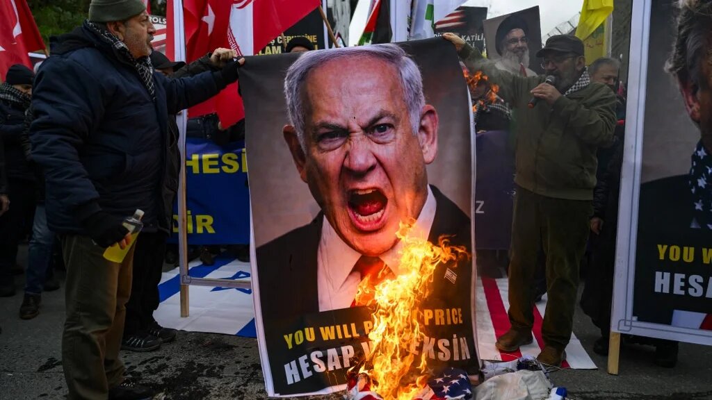 Protestors set fire to an image depicting Israeli Prime Minister Benjamin Netanyahu as they gather to protest against the US and Israel attack of Iran and the killing of the Supreme leader in front of Israel Consulate in Istanbul on March 1, 2026.  (Ozan KOSE / AFP)