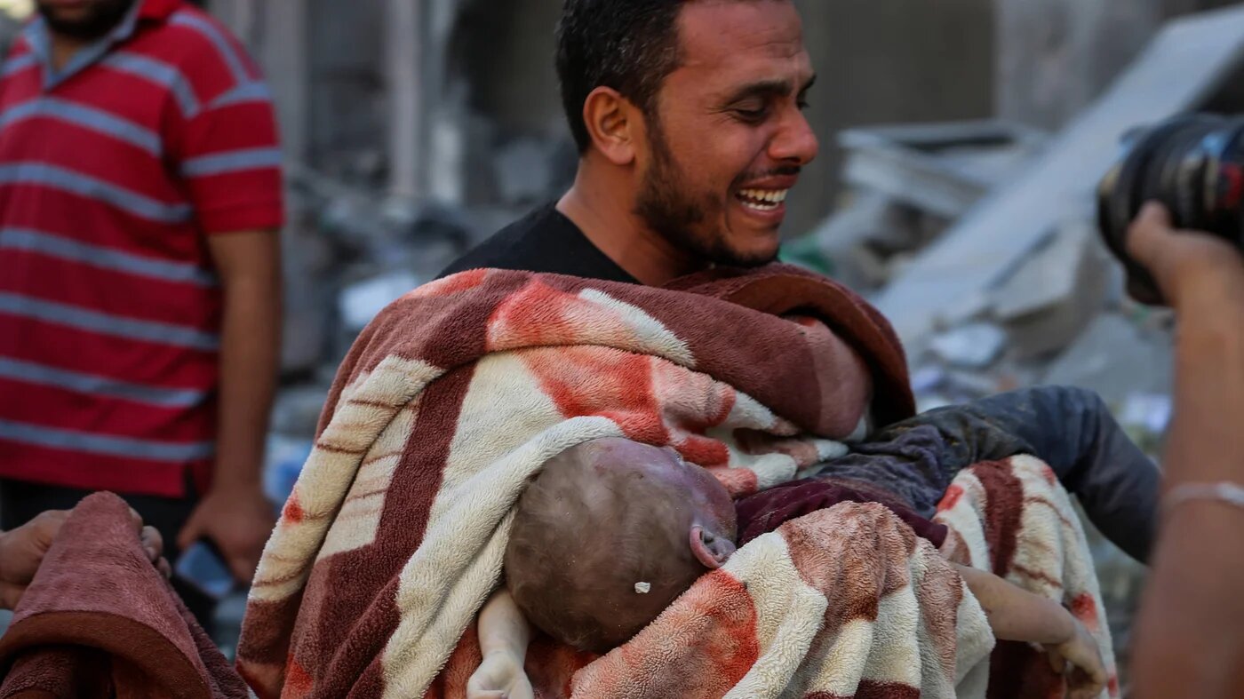 Un homme pleure après avoir sorti un enfant des décombres, le 12 octobre 2023 à Gaza (MEE/Mohammed Hajjar)