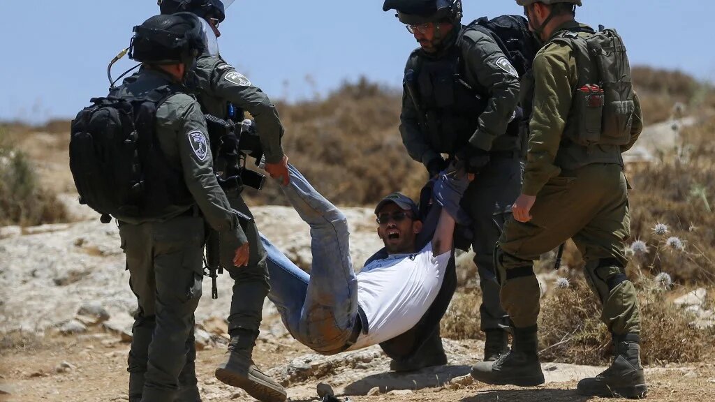 Israeli forces remove a demonstrator during a protest on 1 July 2022 in Masafer Yatta in the Israeli-occupied West Bank (AFP)