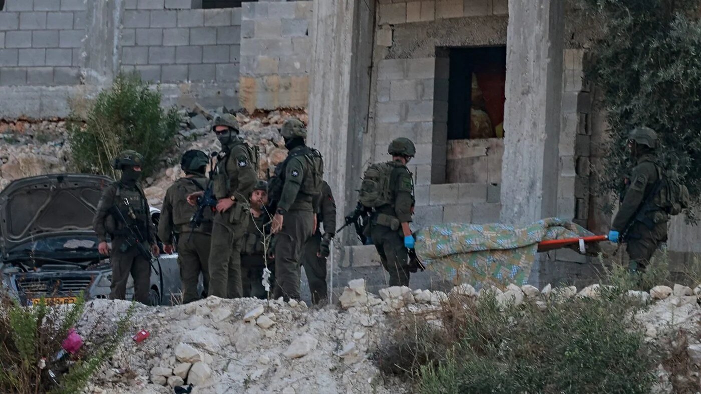 Israeli soldiers remove the body of a Palestinian from a house under construction in Jenin, occupied West Bank, 28 August 2026 (Jaafar Ashtiyeh/AFP)