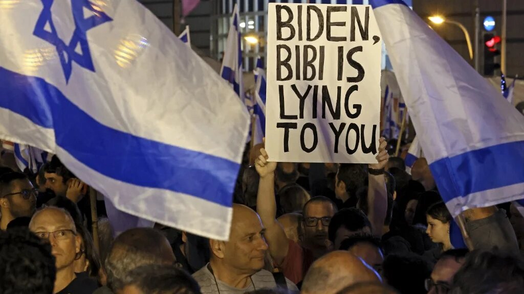 Israelis hold placards and wave flags in Tel Aviv on 28 January 2023 during a protest against controversial government plans to give lawmakers more control of the judicial system (AFP)